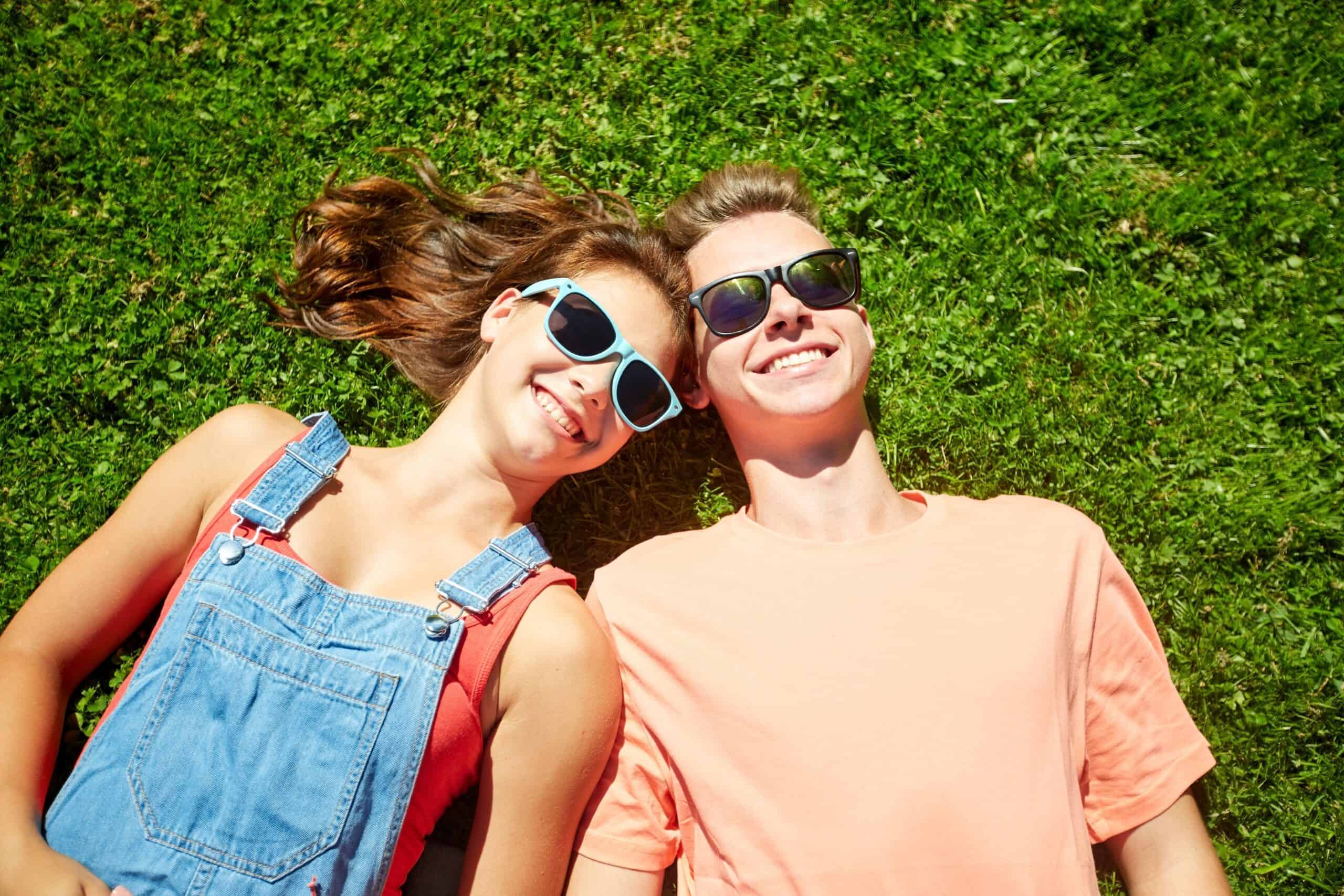 para nastolatków leżąca na trawie 